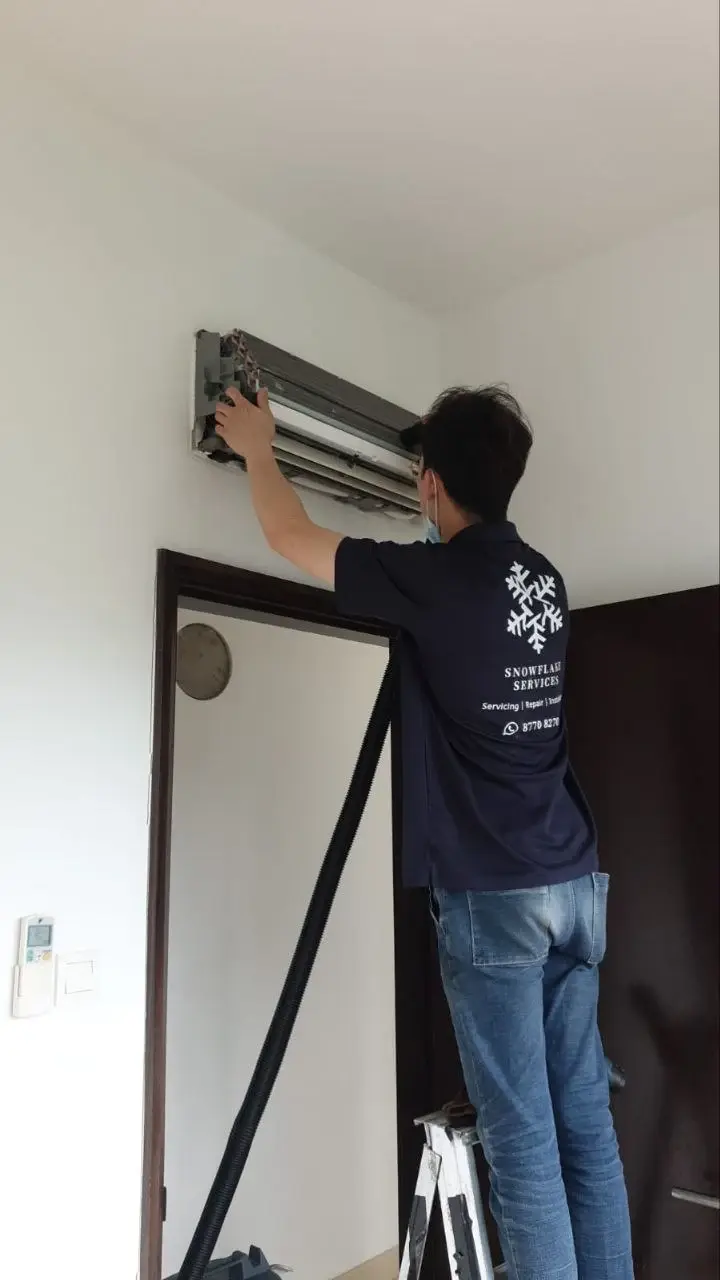 Technician performing routine FCU general servicing on an indoor fan coil unit.
